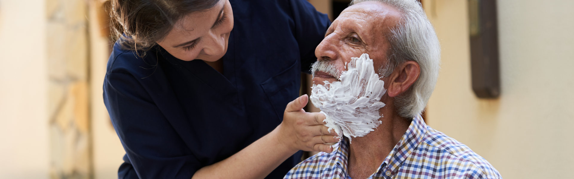 caregiver shave the beard of senior man